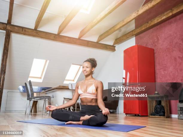 smiling young woman practicing yoga - holzbalken stock-fotos und bilder