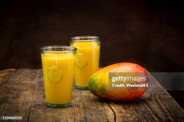 mango and two glasses of mango lassi with curcuma - lassi stock pictures, royalty-free photos & images