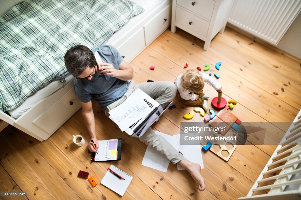 Father with his little son working from home