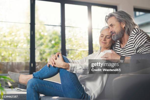 happy senior couple sitting at home - baby boomer couple stock-fotos und bilder