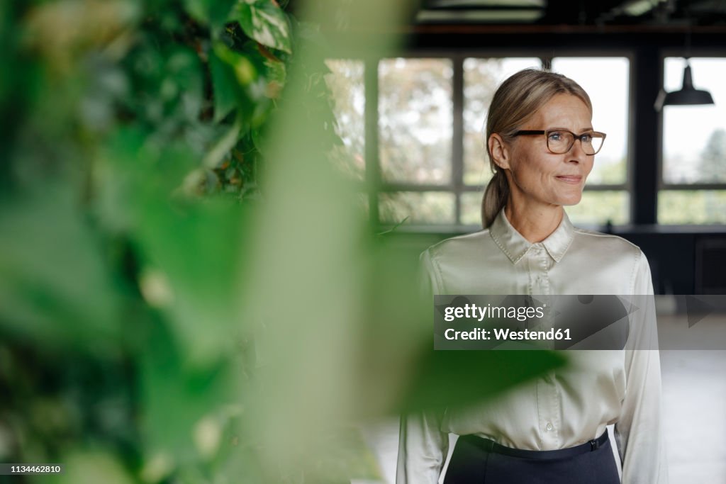 Smiling businesswoman in green office