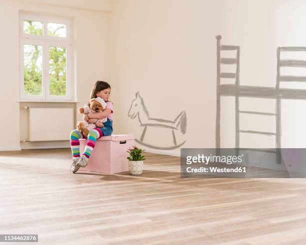 girl in empty apartment sitting on a box holding teddy - children room wall stock pictures, royalty-free photos & images