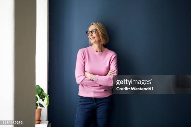portait of confident mature woman at home - three quarter length stockfoto's en -beelden