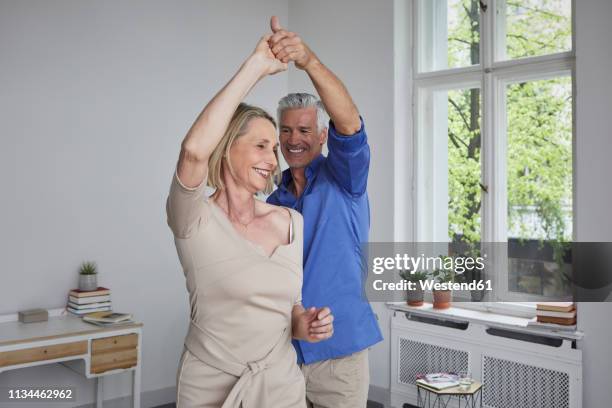 happy mature couple dancing at home - 50 59 years home stock pictures, royalty-free photos & images