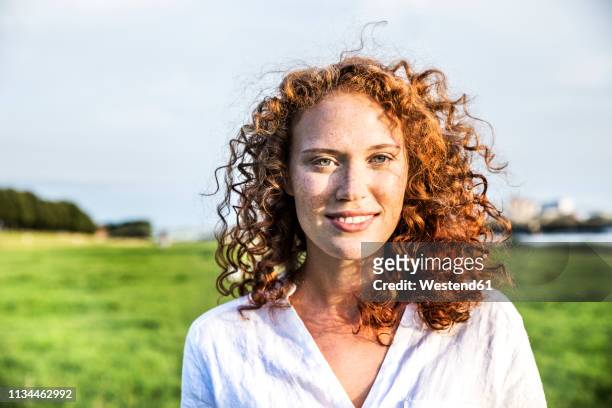 portrait of freckled young woman with curly red hair - freckle stock pictures, royalty-free photos & images