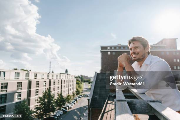 businessman standing on balcony, smiling - ノルトラインヴェストファーレン州 ストックフォトと画像