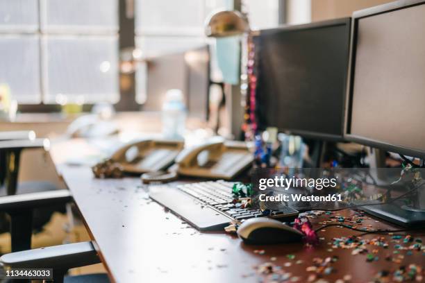 desk with confetti and streamers on computer after a birthday party - messy table after party 個照片及圖片檔