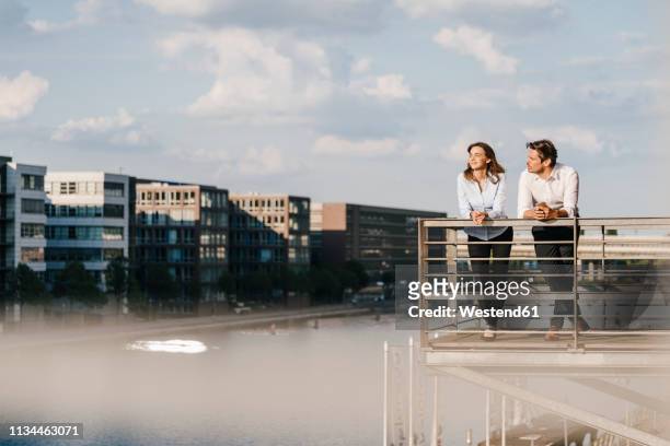 business people standing on balcony - city break stock-fotos und bilder