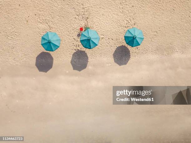 bali, kuta beach, three beach umbrellas, aerial view - beach umbrella sand stock pictures, royalty-free photos & images