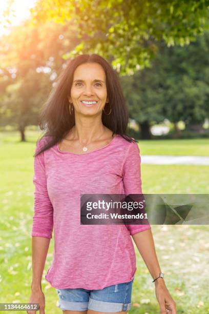 portrait of relaxed mature woman in a park in summer - short hair photos et images de collection