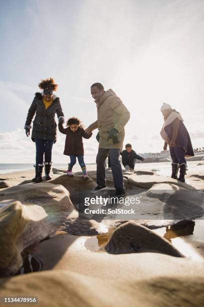 three generation family walking on the beach - multi generation family winter stock pictures, royalty-free photos & images