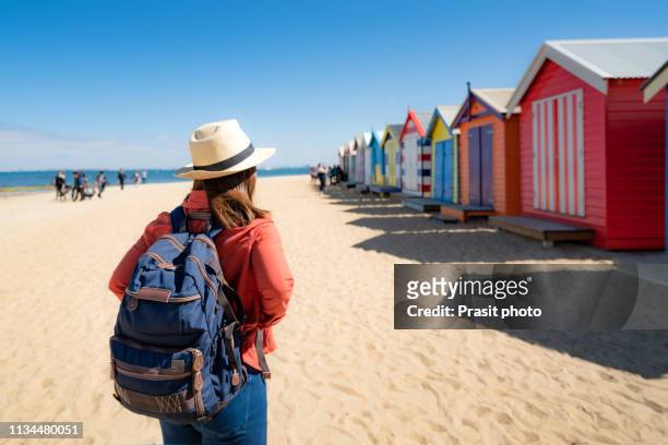 asian woman traveler seesighting brighton bathing boxes on white sandy beach at brighton beach in melbourne, victoria, australia. - australian tourism stock pictures, royalty-free photos & images