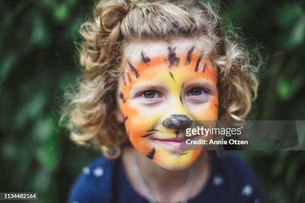 curly haired girl with tiger face paint - tiger girl stock pictures, royalty-free photos & images