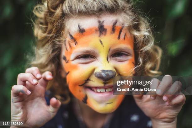 girl pretending to be a tiger - geschminkt gezicht stockfoto's en -beelden