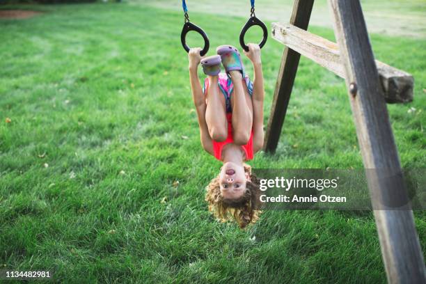 girl hanging upsidedown - acrobatiek stockfoto's en -beelden