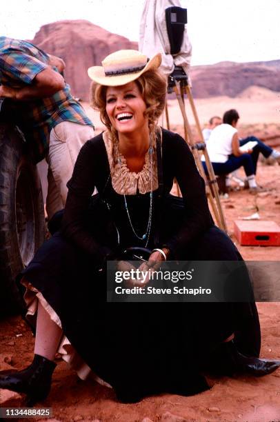 View of Tunisian-born Italian actress Claudia Cardinale, in costume, as she laughs with the crew, on location in Monument Valley for the film 'Once...