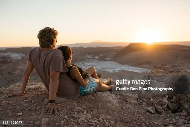 couple on cliff, valle de la luna (valley of the moon), atacama desert, el norte grande, chile - chile desert stock pictures, royalty-free photos & images