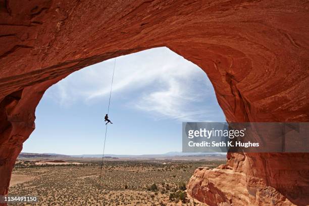 woman abseiling from arch, moab, utah, usa - adrenaline bildbanksfoton och bilder