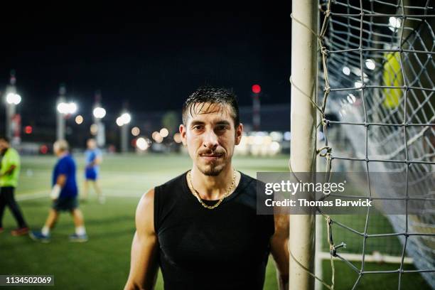 portrait of male soccer goalie standing by goal during evening game - personal strength stock pictures, royalty-free photos & images