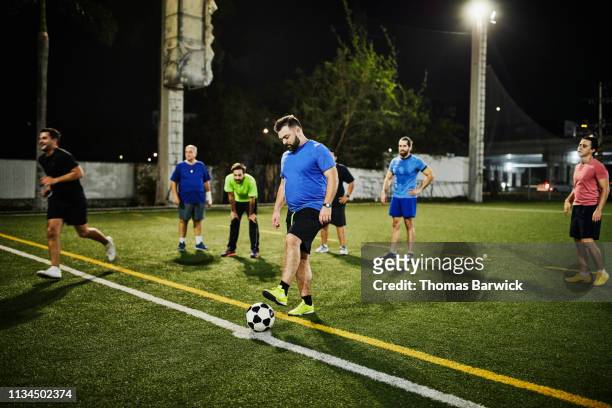 man preparing for penalty kick during evening soccer match with friends - football team running stock pictures, royalty-free photos & images
