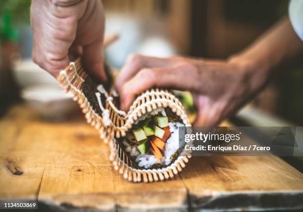 making sushi at home, roll up 1 - sushi rice stock pictures, royalty-free photos & images