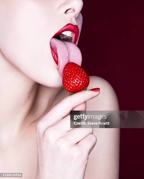 woman licking strawberry - licking stock pictures, royalty-free photos & images