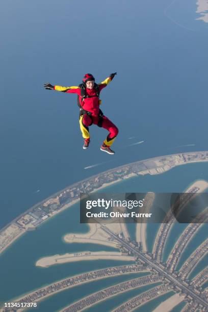 woman skydiving over rural landscape - dubai people stock pictures, royalty-free photos & images