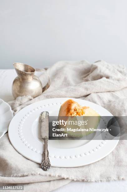 plate of melon with butter knife - メロン ストックフォトと画像