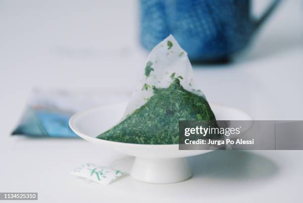 fukamushi sencha green tea bag with blue cup in the background. - ティーバッグ ストックフォトと画像