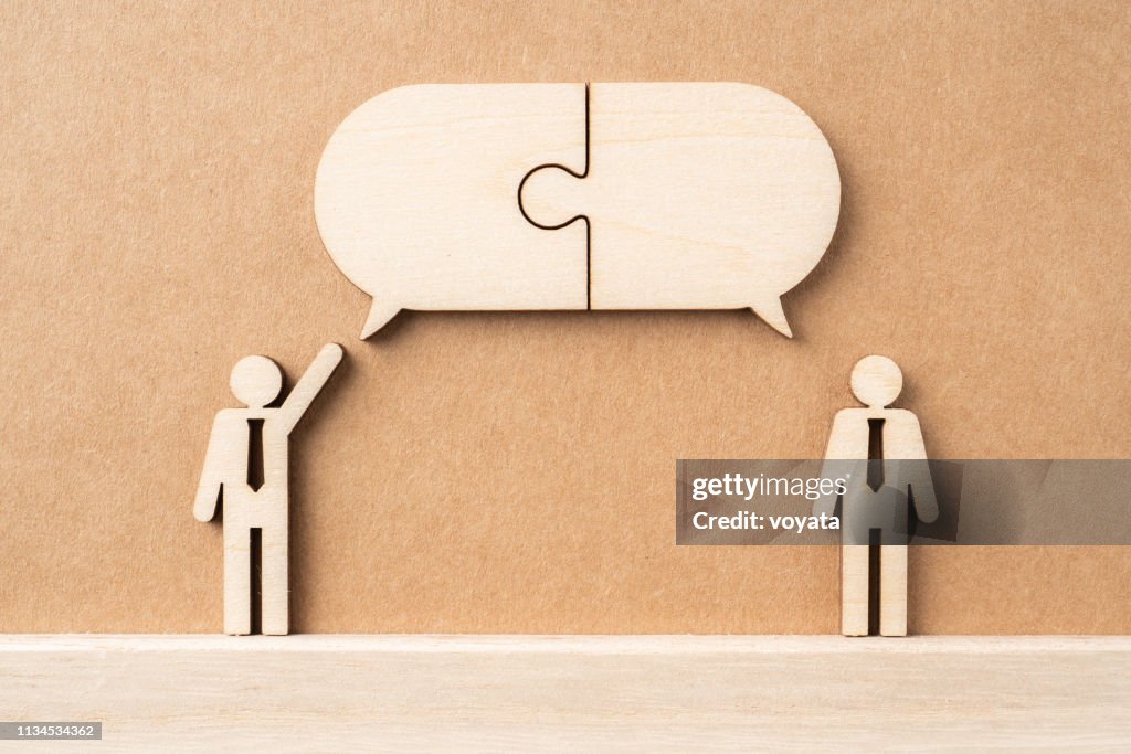 Wooden businessman with conversation concept