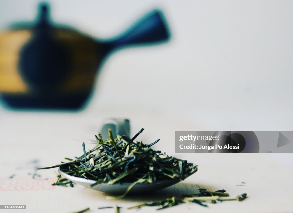 Stems and leaves of Kukicha Karigane Japanese green tea, kyusu teapot in the background.