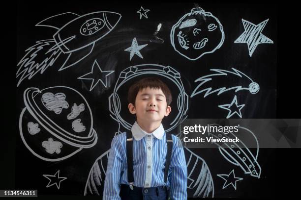 primary school girl standing in front of the blackboard - tafel kind rakete stock-fotos und bilder