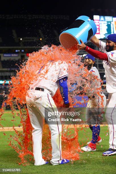 Nomar Mazara of the Texas Rangers and Rougned Odor dump the coolers on Elvis Andrus after the win against the Houston Astros at Globe Life Park in...