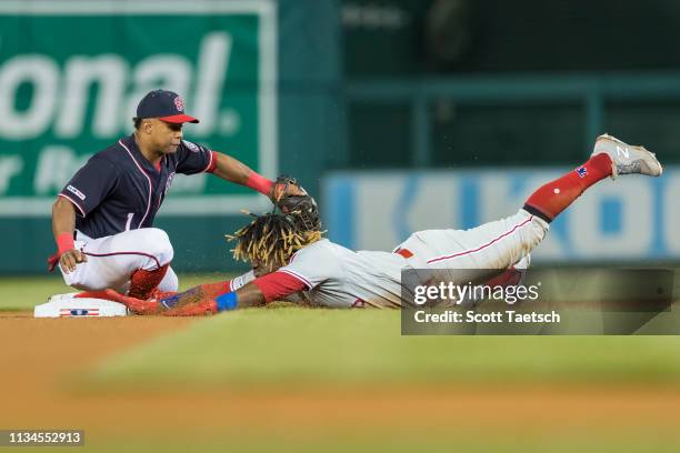 Odubel Herrera of the Philadelphia Phillies slides safely into second base ahead of the throw to Wilmer Difo of the Washington Nationals during the...