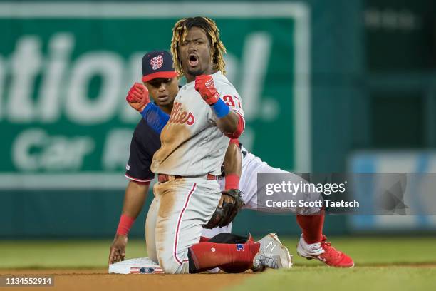 Odubel Herrera of the Philadelphia Phillies celebrates after sliding safely into second base in front of Wilmer Difo of the Washington Nationals...