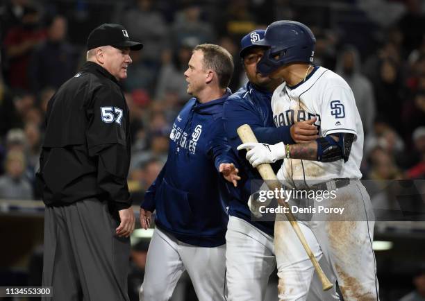 San Diego Padres manager Andy Green argues with umpire Mike Everitt as bench coach Rod Barajas holds back Manny Machado after Green was ejected from...