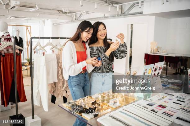 candid portrait of two women looking at jewellery in boutique - jewellery shopping stock pictures, royalty-free photos & images