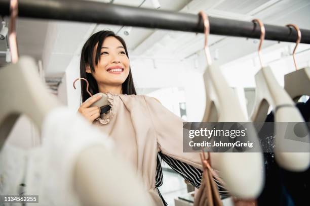 candid portret van vrouw selecteren kleding op het spoor - women wearing see through clothing stockfoto's en -beelden