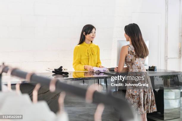 ropa de compra de cliente femenina en boutique moderno - devolver fotografías e imágenes de stock