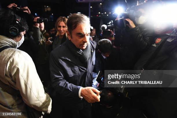 Former Nissan Chairman Carlos Ghosn and his wife Carole are surrounded by members of the press as they arrive at their residence in Tokyo on April 3,...