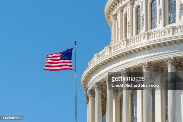 us capitol building dome with american flag - edificio federal fotografías e imágenes de stock
