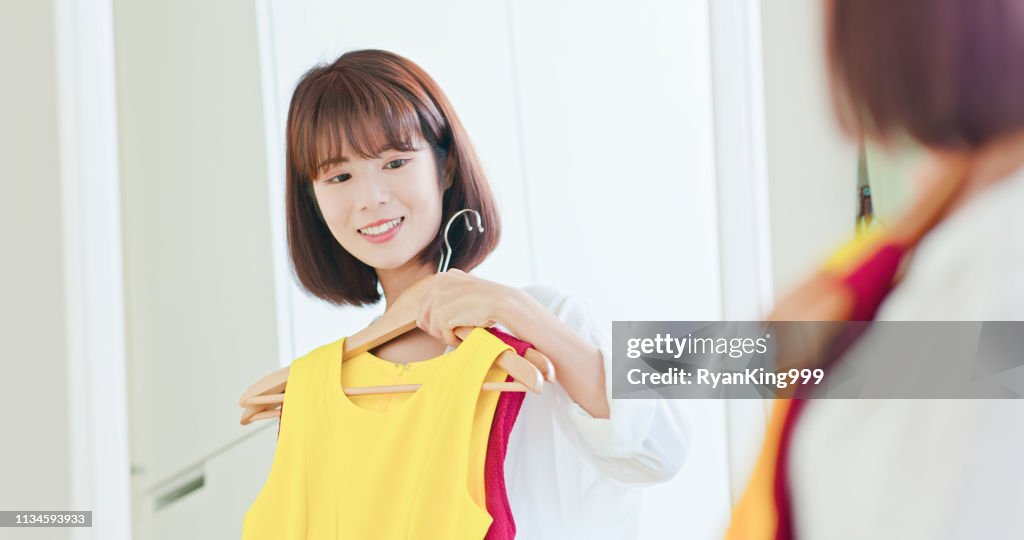 Asian girl trying dress happily
