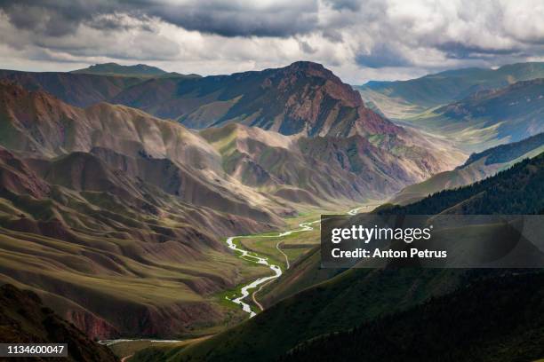 view from pass to green valley and the mountains. kyrgyzstan - kirgisistan stock-fotos und bilder