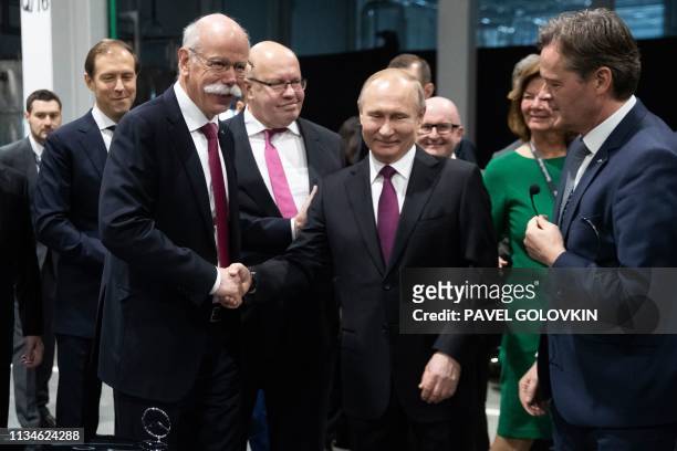 Russian President Vladimir Putin shakes hands with Chairman of the German multinational automotive corporation Daimler AG Dieter Zetsche during the...