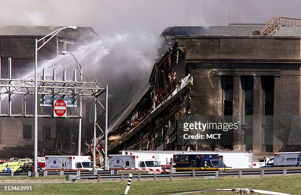 Emergency crews try to extinguish fires at the Pentagon after an airplane crashed into the building following similar attacks on the World Trade...
