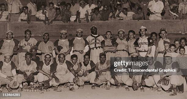 Martin Dihigo stands in the back row, center, in the uniform of an industrial league team, Union Laguna, while posing with an all-star team from a...