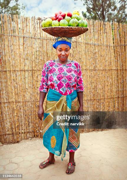 ruandische frau mit korb voller früchte - afrikanerin korb tragen stock-fotos und bilder