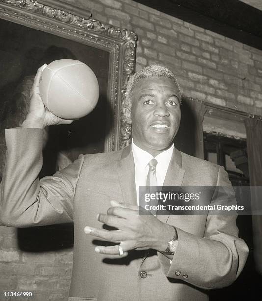 Jackie Robinson, named General Manager of the Brooklyn Dodgers football team, poses with a football on May 3, 1966 in the Brooklyn borough of New...