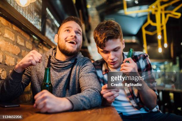 men drinking beer and betting - pub mates stock pictures, royalty-free photos & images