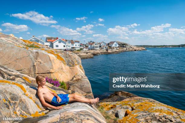 teen sunbathing on the rocky coast of sweden - bohuslan stock pictures, royalty-free photos & images